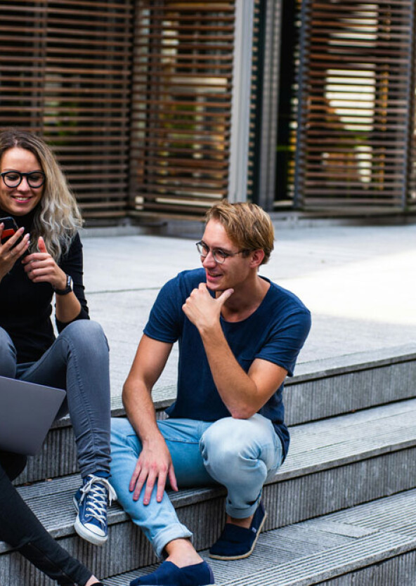 Students on steps looking at computer